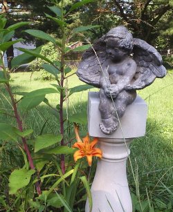 daylily with pokeweed and angel on concrete pilaster